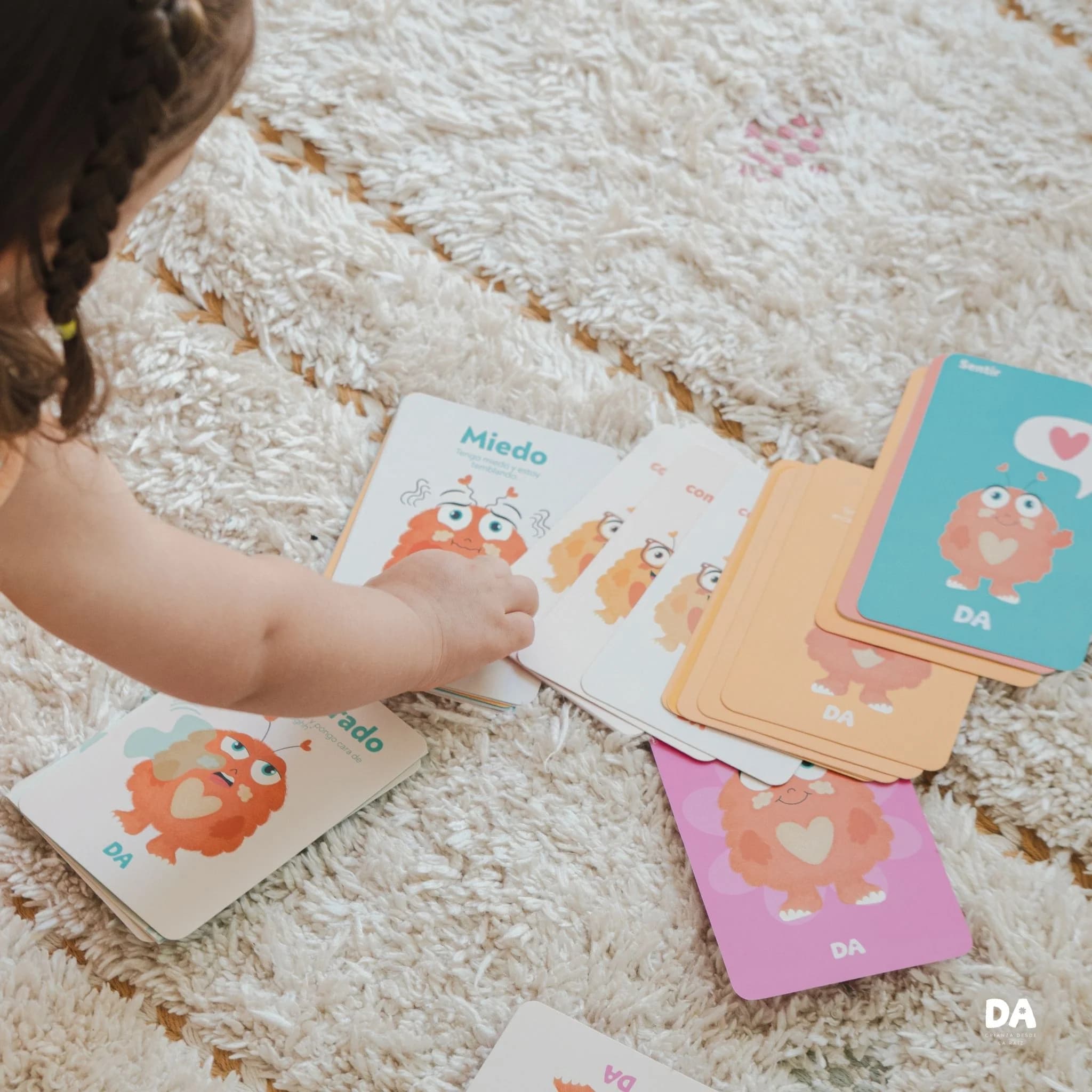 Niña explorando las tarjetas ilustradas de Las Emociones de Oli
